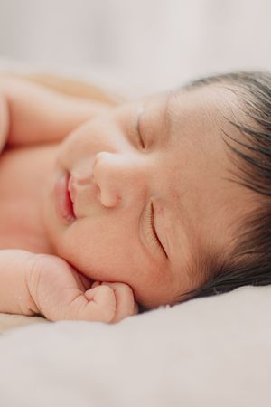 Gentle close-up portrait of a sleeping newborn baby's face.