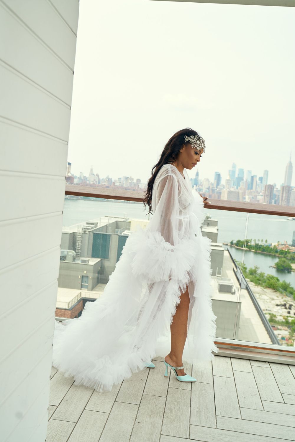 Bridal fashion shot on balcony overlooking city skyline with white flowing dress. at the WIlliam Vale Hotel