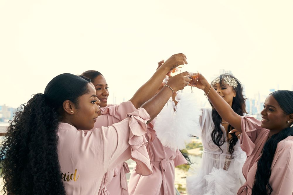 A group in matching pink robes raises champagne glasses for a celebratory toast. at the WIlliam Vale Hotel