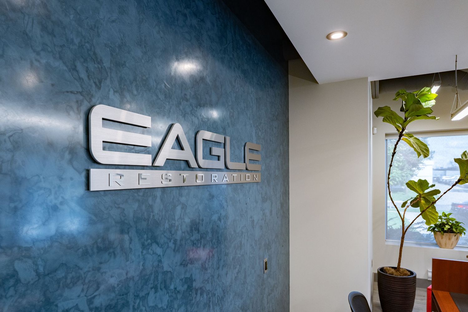 Modern office interior with blue textured walls and Eagle company branding signage.
