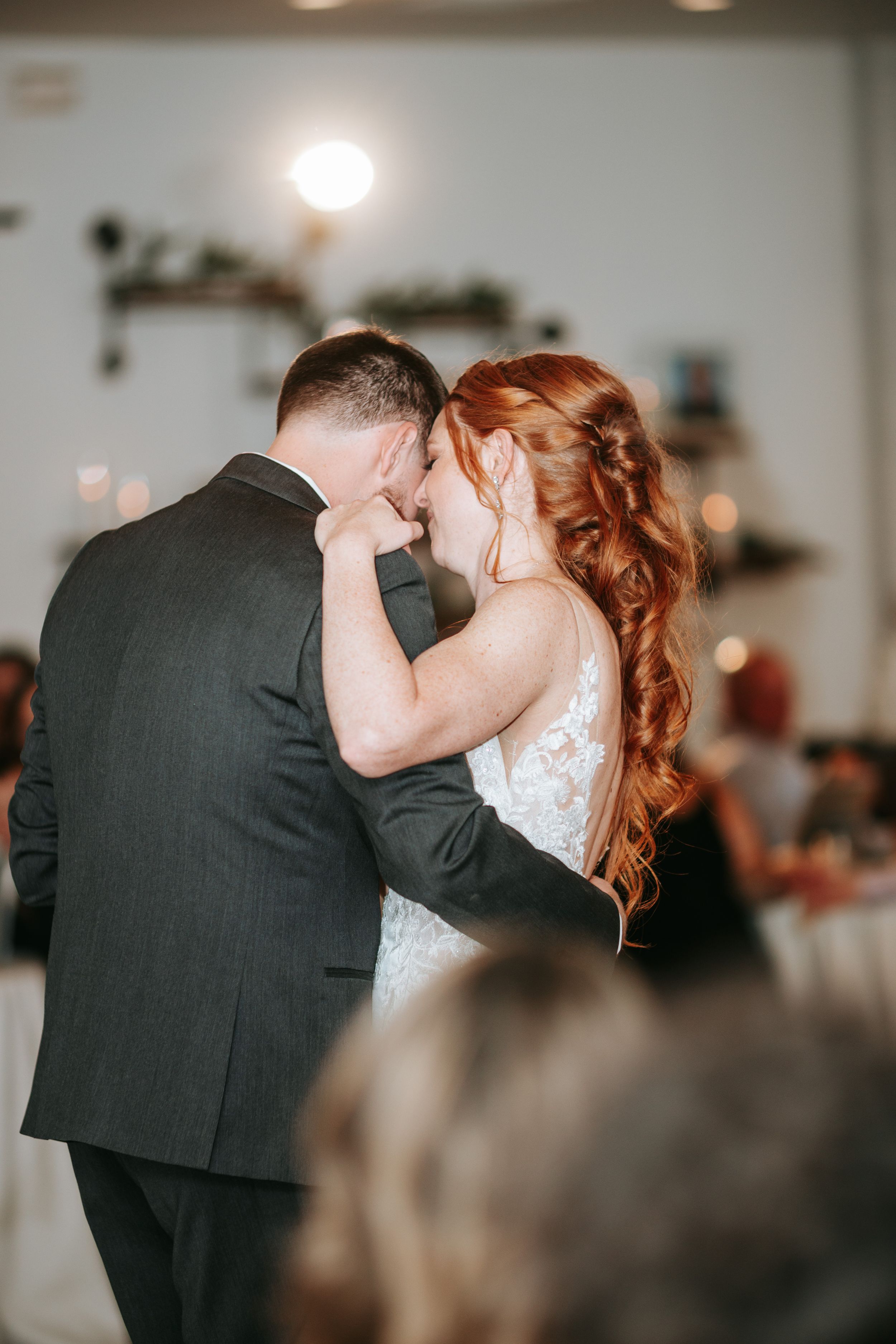 A romantic first dance moment between newlyweds sharing an intimate embrace on their wedding day.
