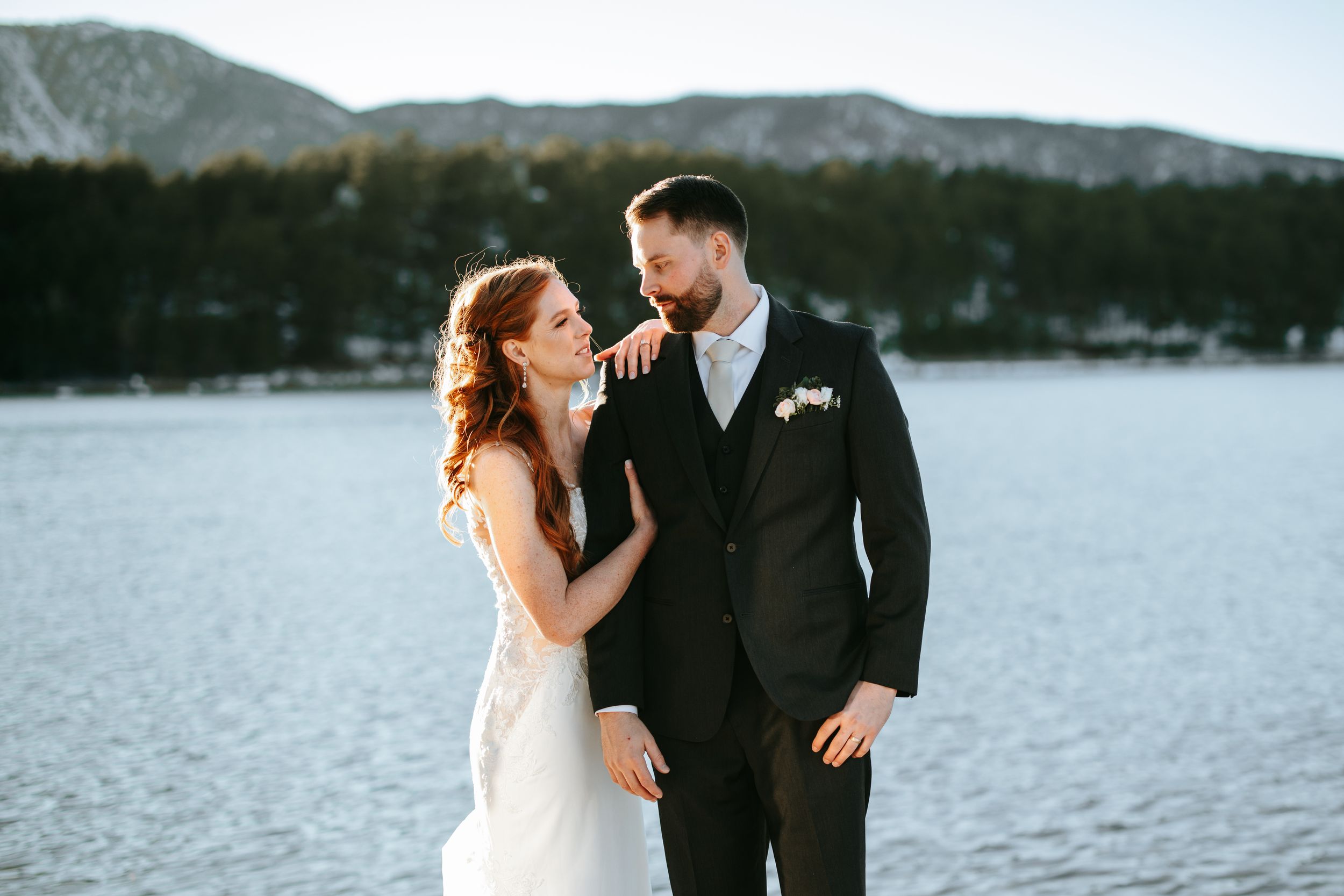 Romantic lakeside wedding photos with mountain scenery in the background.