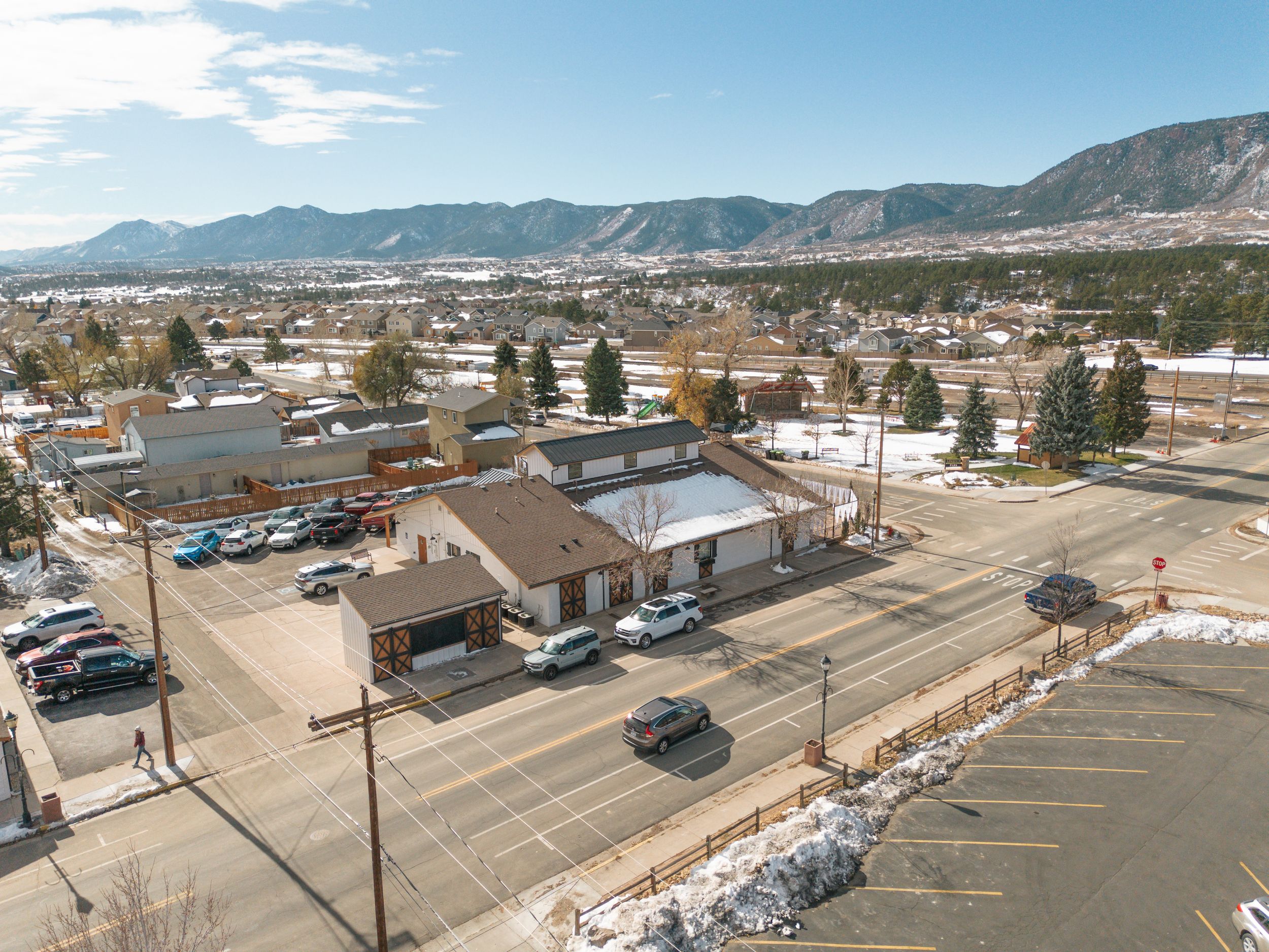 Aerial view of a small town with mountains in the background and commercial buildings along a main street.