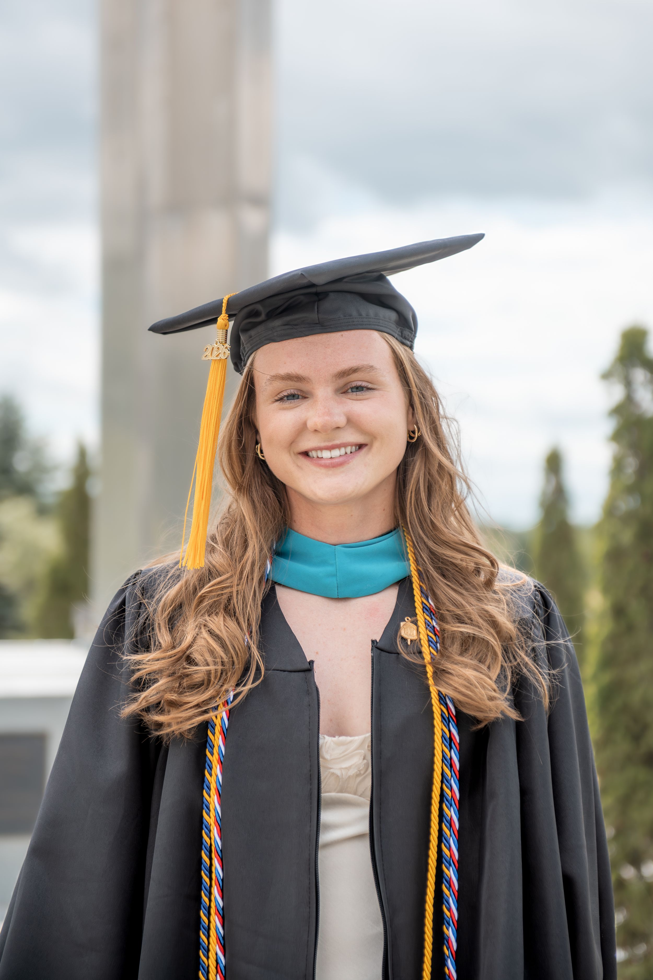 Graduation photo shoot with cap and gown, on campus at Husson, near Bangor, Maine