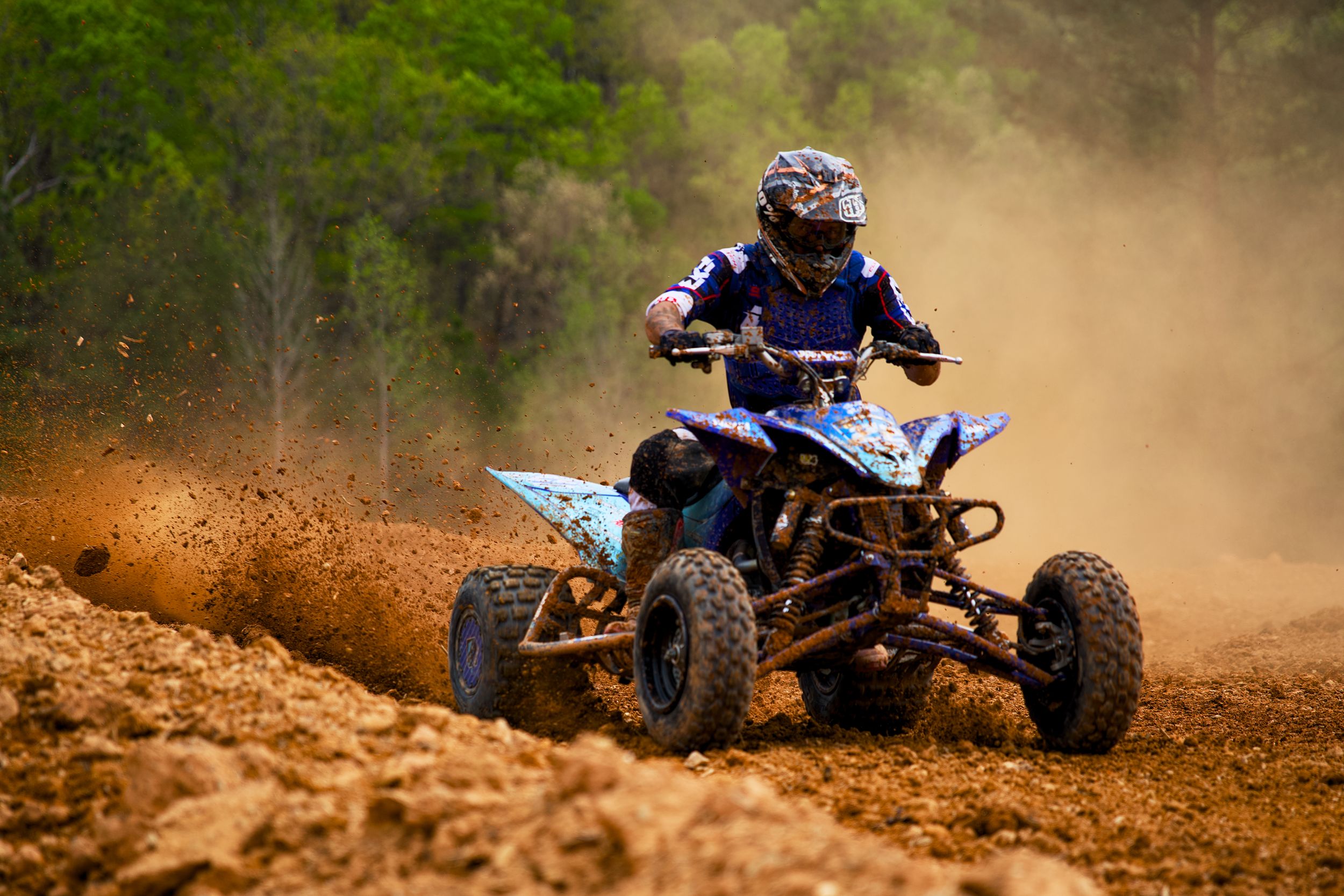 Blue ATV throwing up dirt