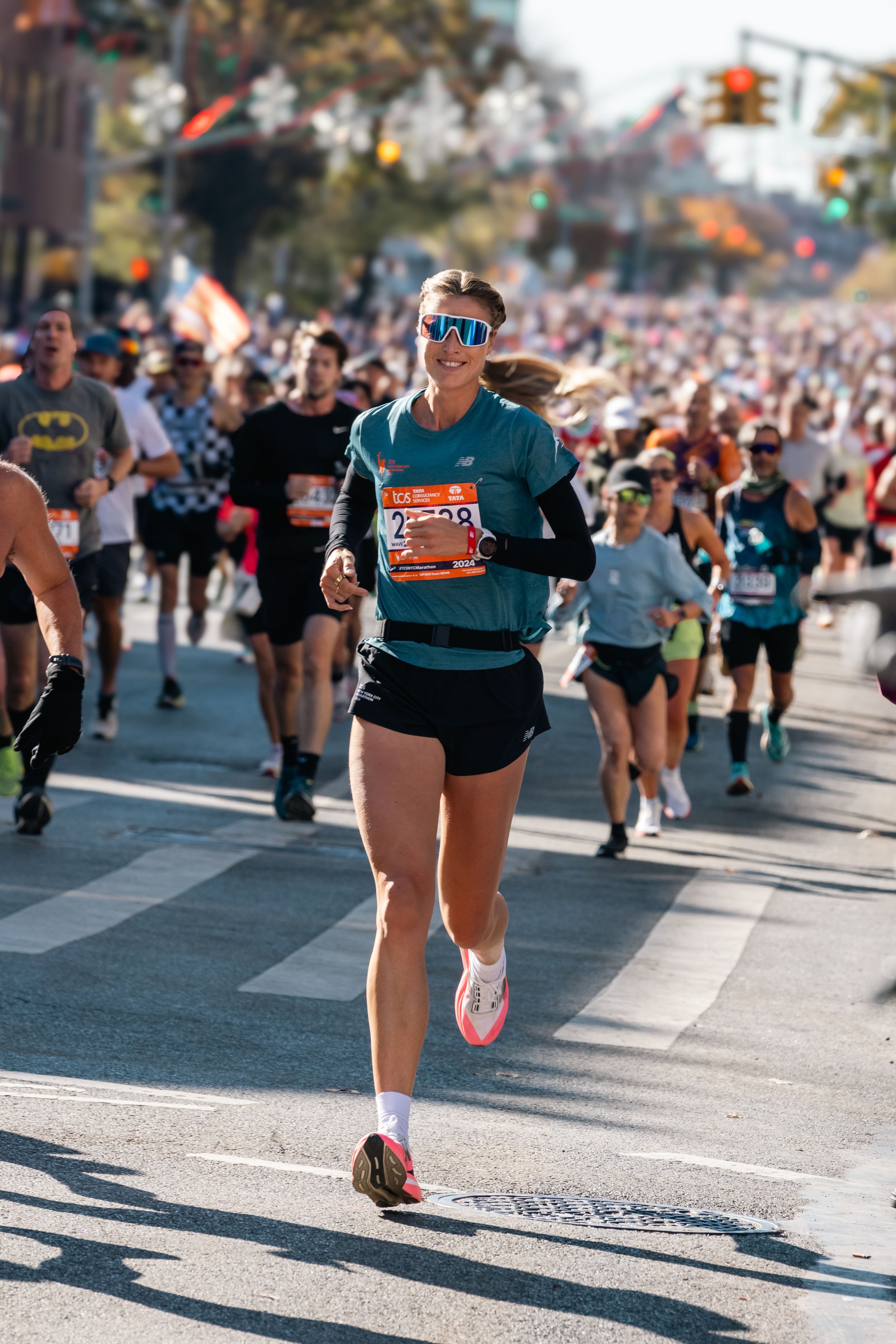 Marathon runners competing on a sunny city street during a race.