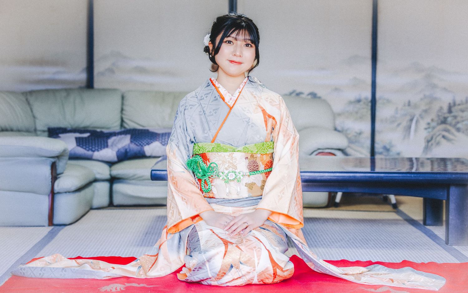 Elegant kimono ensemble featuring peach and green tones in a traditional Japanese room.