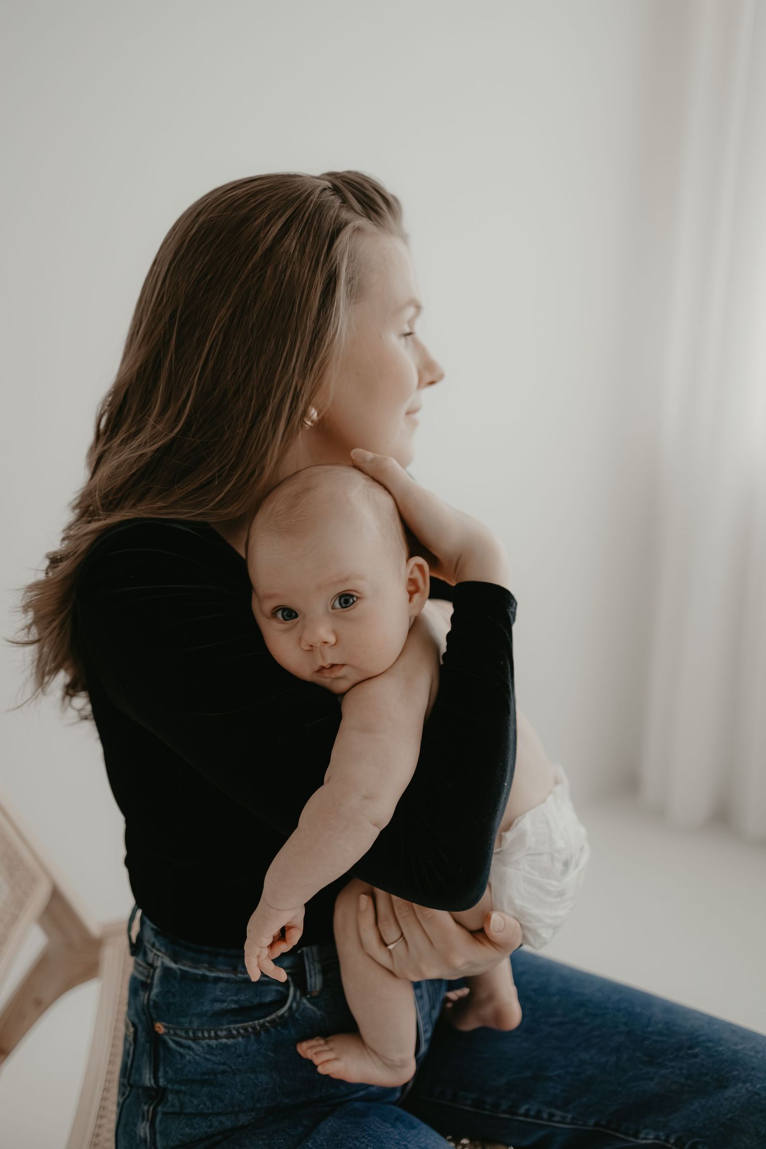 Äitilapsikuvaus, jossa äiti pitää sylissään vauvaa