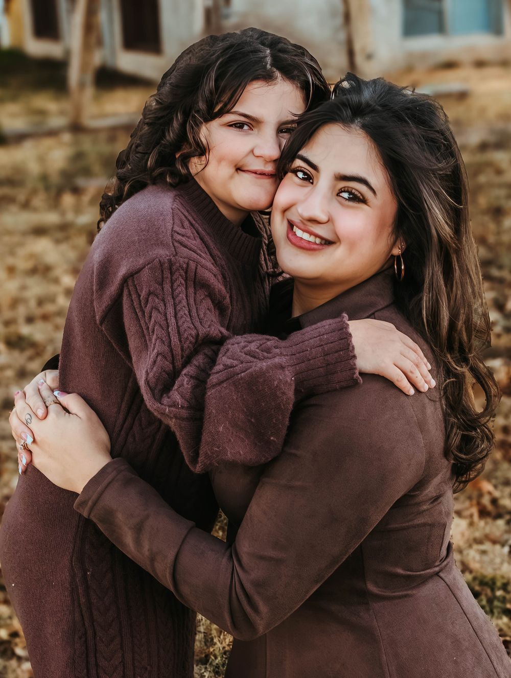 Affectionate portrait series in matching brown sweaters against stone wall background.