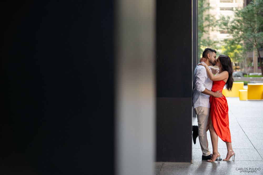 Stylish couple in framed doorway with urban architecture background.