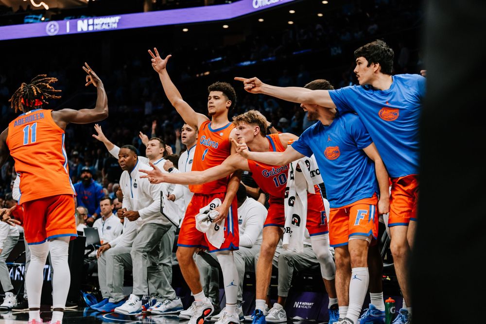 Florida Gators basketball team celebrates enthusiastically on the sideline during a college game.