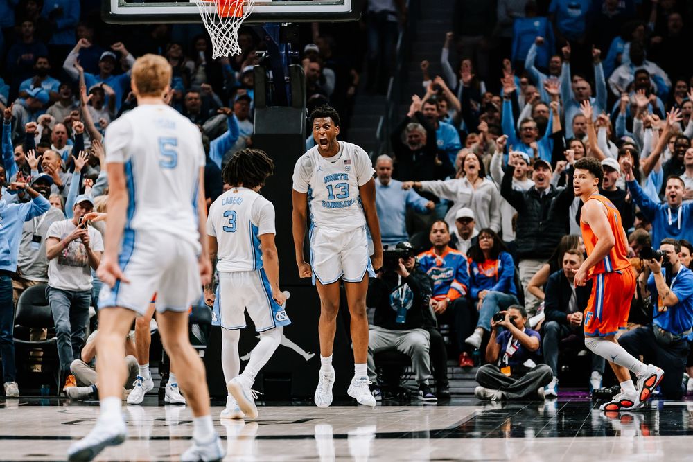 North Carolina Tar Heels players celebrate as a Florida Gators player reacts during a college basketball game.