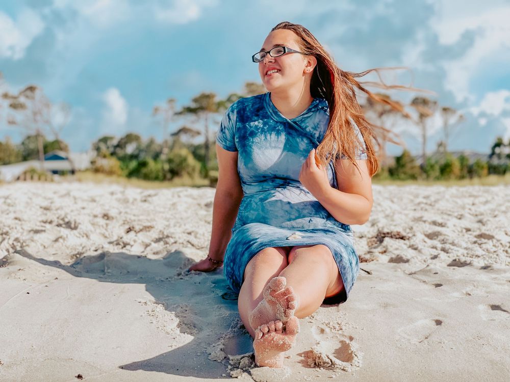 A series of cropped photos showing sandy feet and denim shorts at the beach on a sunny day.