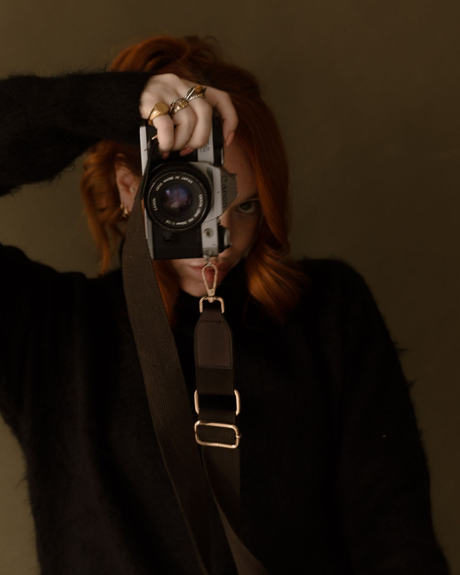 Series of moody dark photos showing a camera being used to take mirror selfies in dramatic shadows.