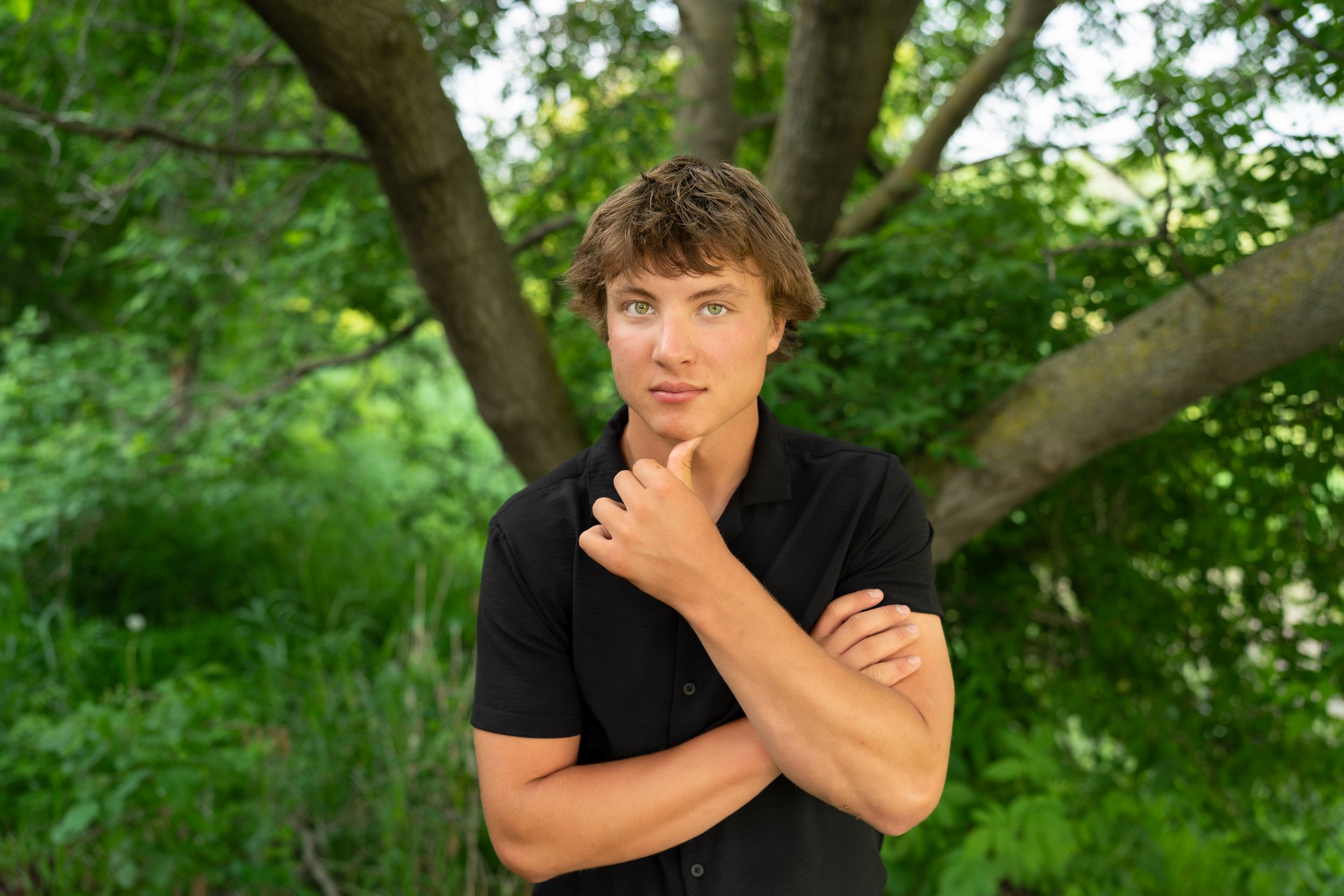Person standing in lush green forest during summer makes a series of playful expressions and gestures.