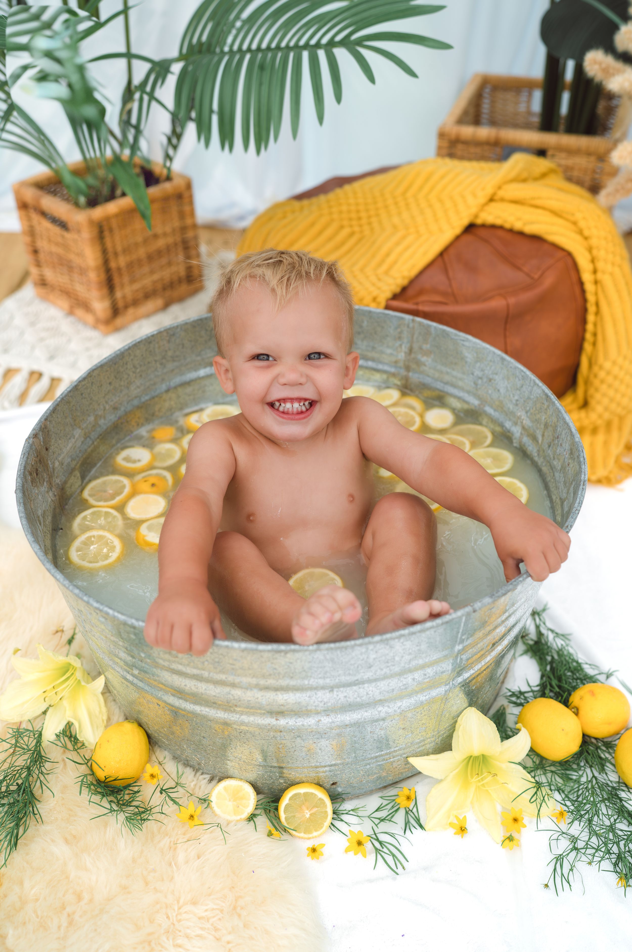 A cheerful bath time scene with lemons and greenery decorating a galvanized metal tub surrounded by yellow accents.