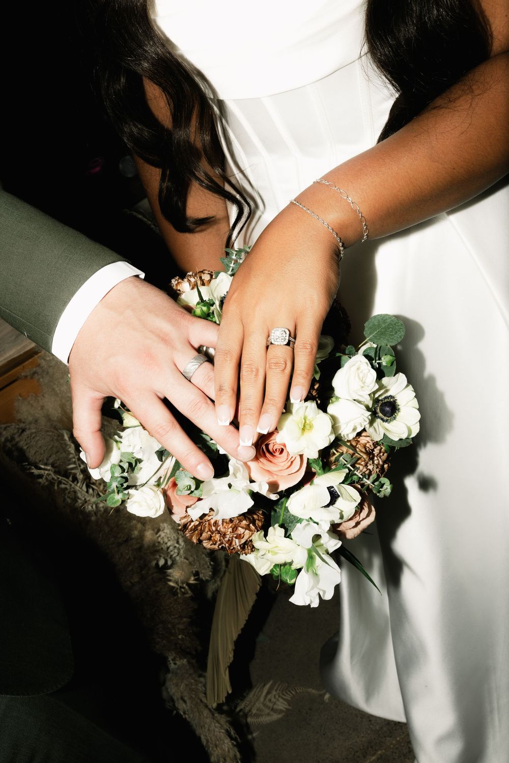 Close-up of hands arranging delicate white floral decorations on a table.