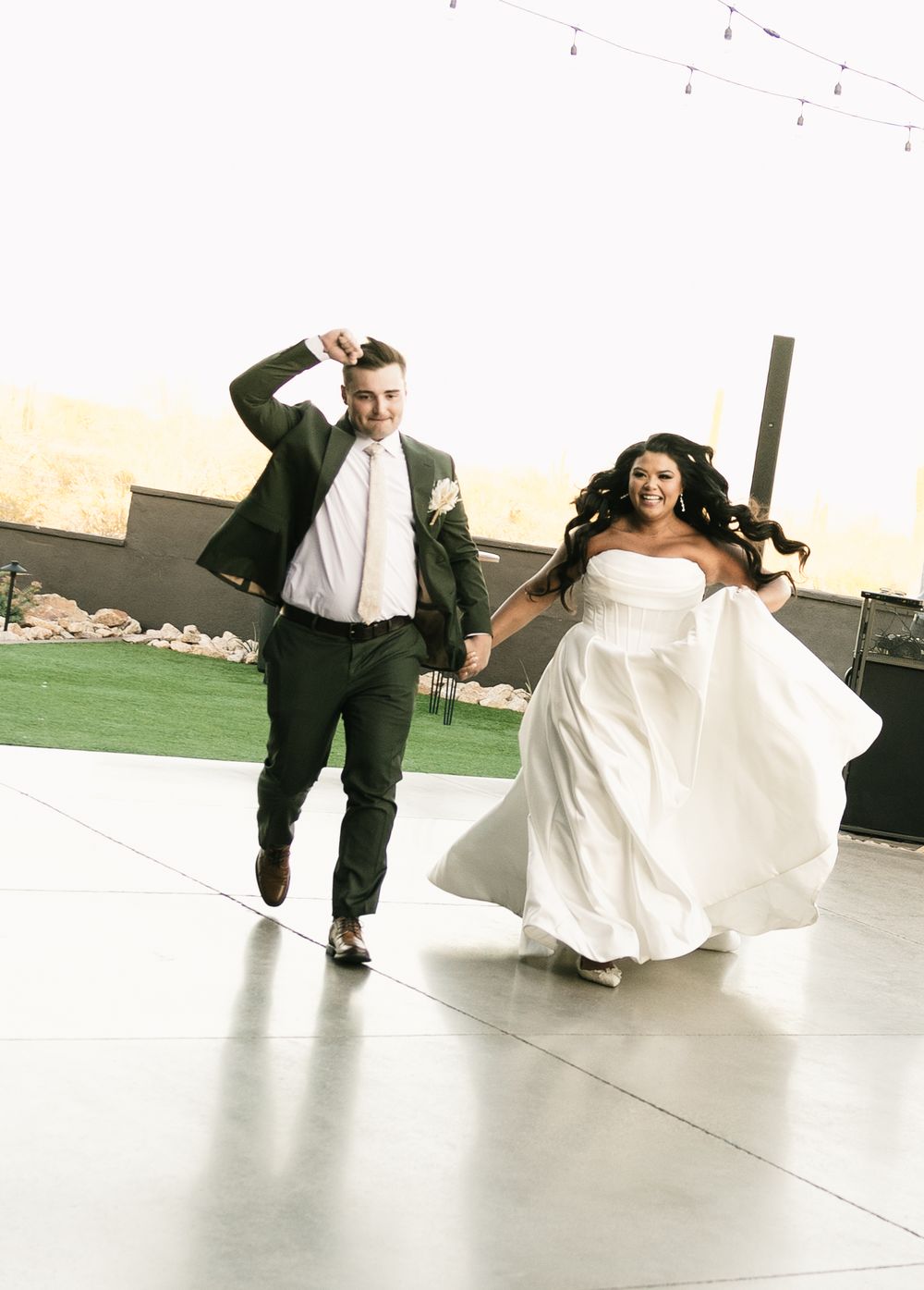 A couple performs a dramatic dip dance move on a bright white dance floor.