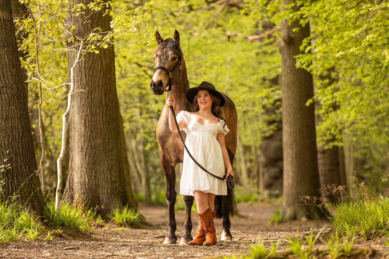 A beautiful black and white paint horse stands with a person on a sunny autumn day outdoors.