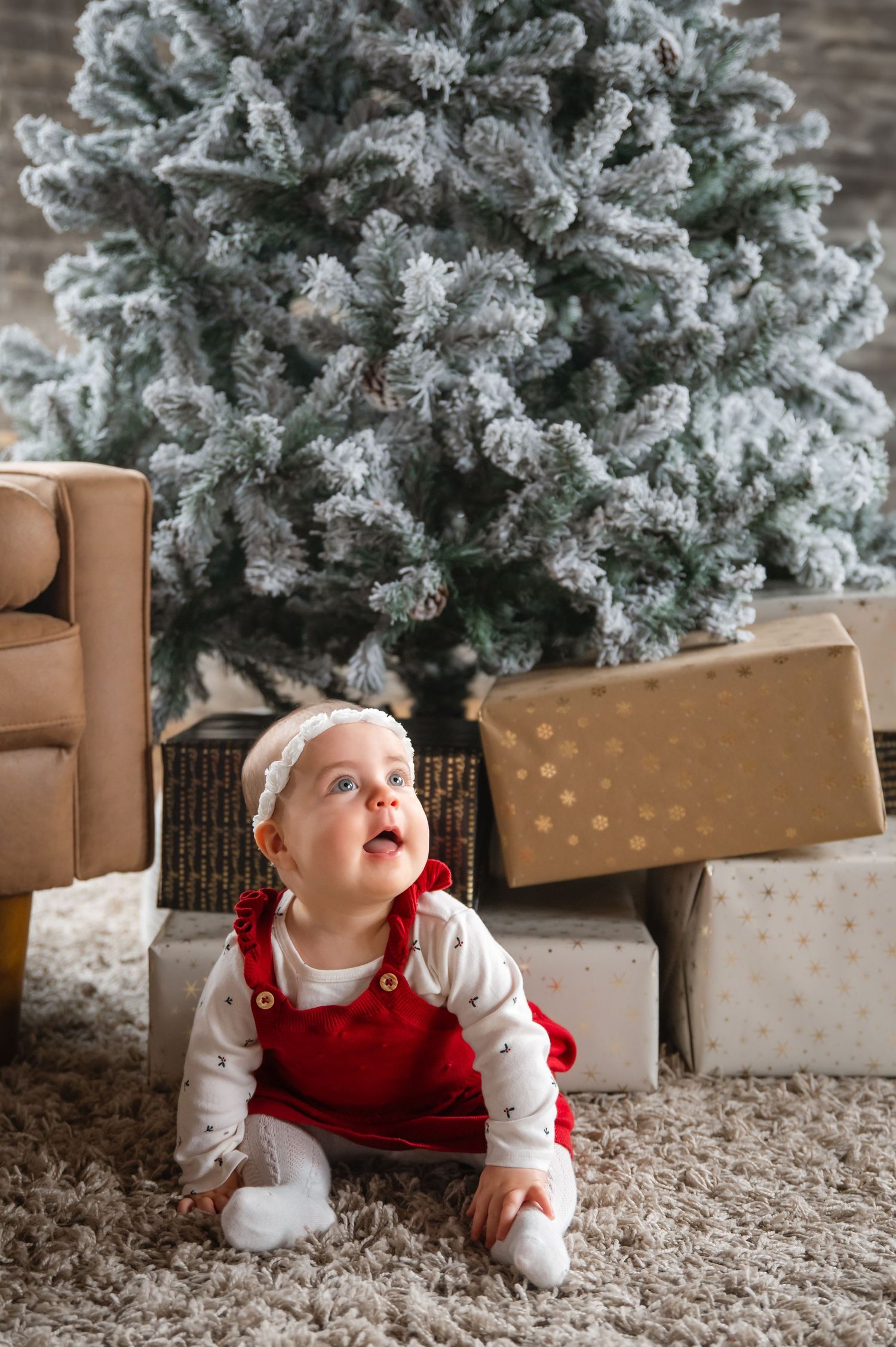 Family enjoying a playful moment together at a Christmas tree farm with evergreen trees in the background on a cloudy day.