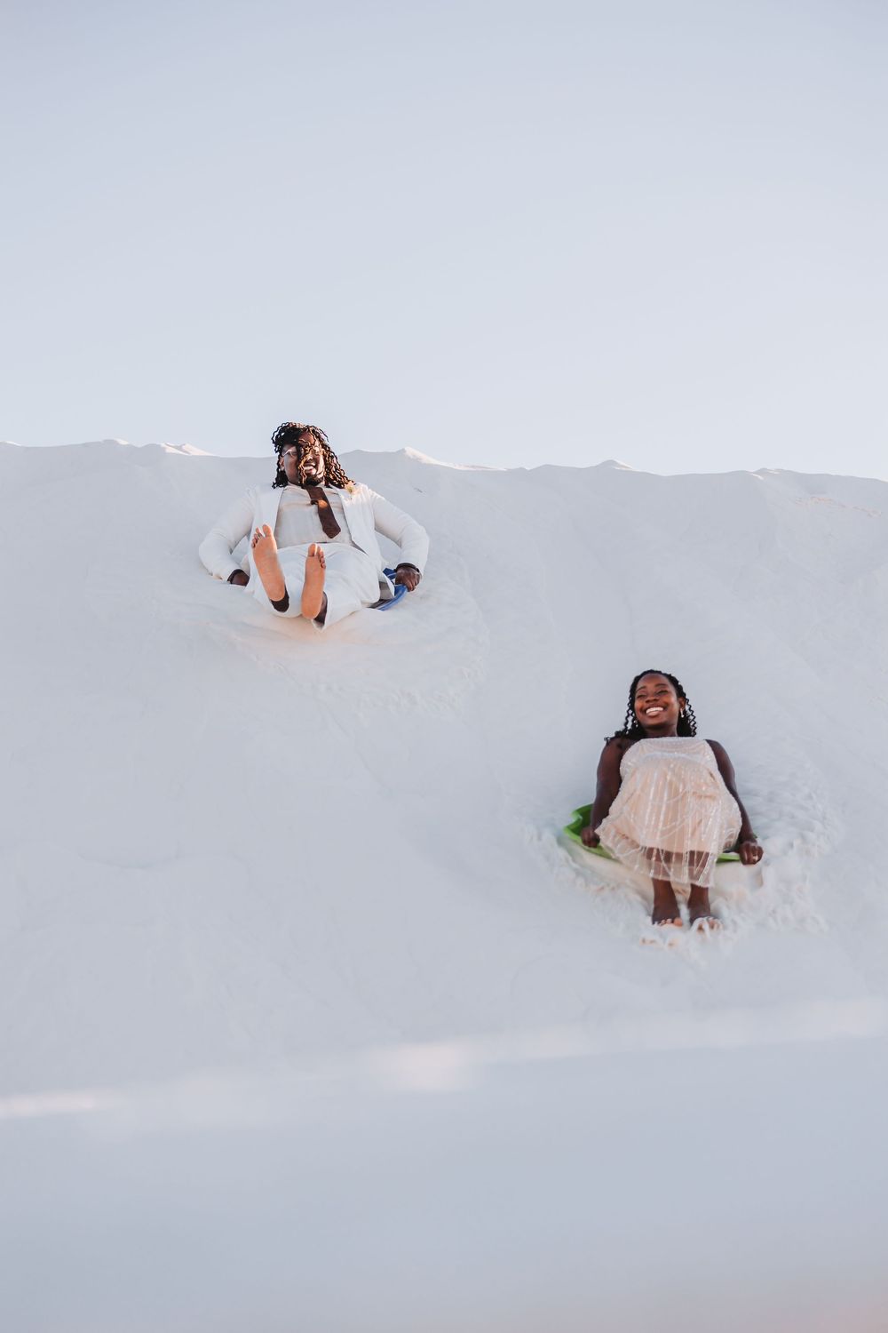 A group of progressive photos shows someone having fun rolling and sliding down a snowy hill outdoors.