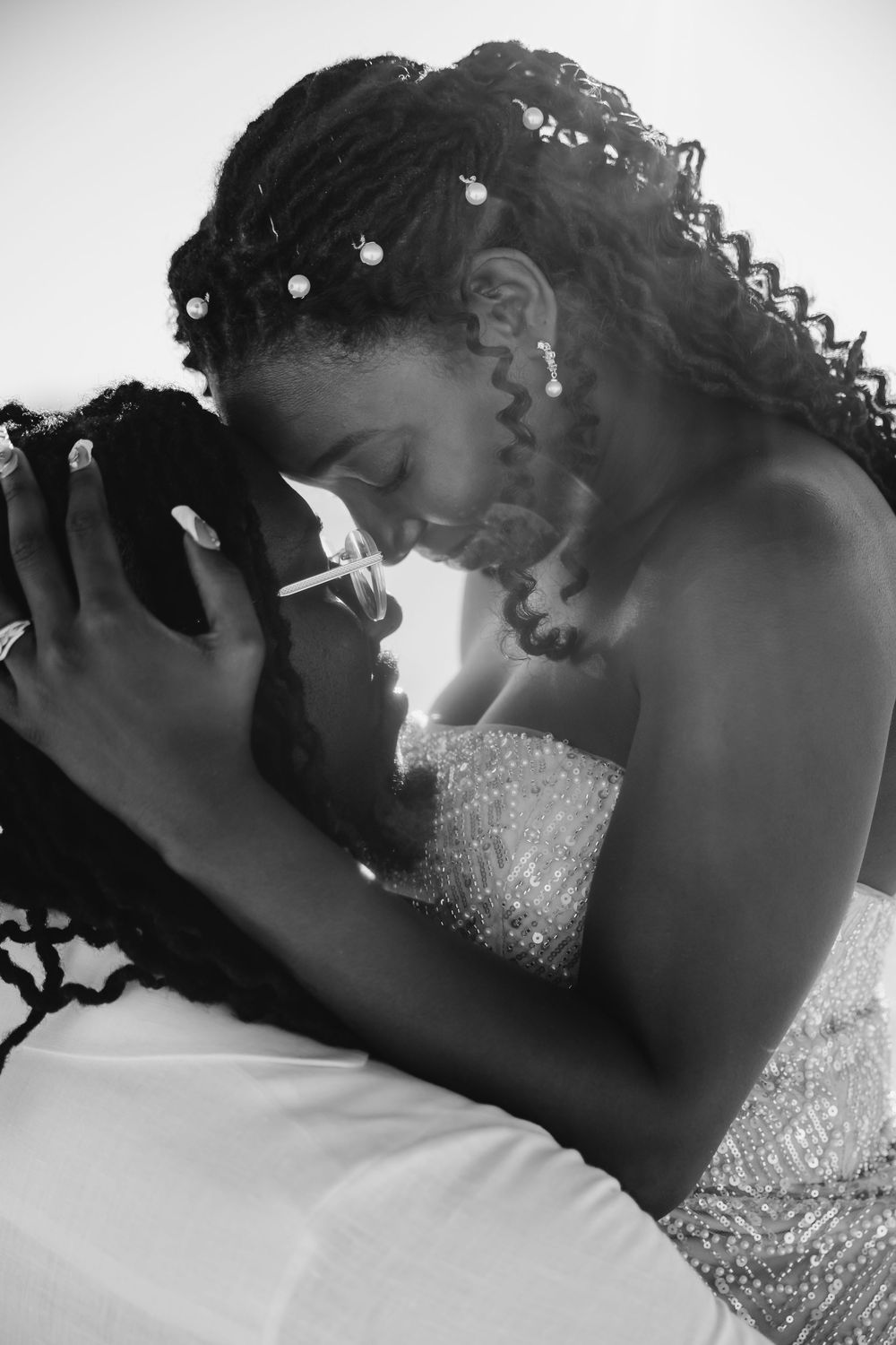 A tender black and white portrait of a bride in a sparkly wedding dress enjoying an intimate moment.