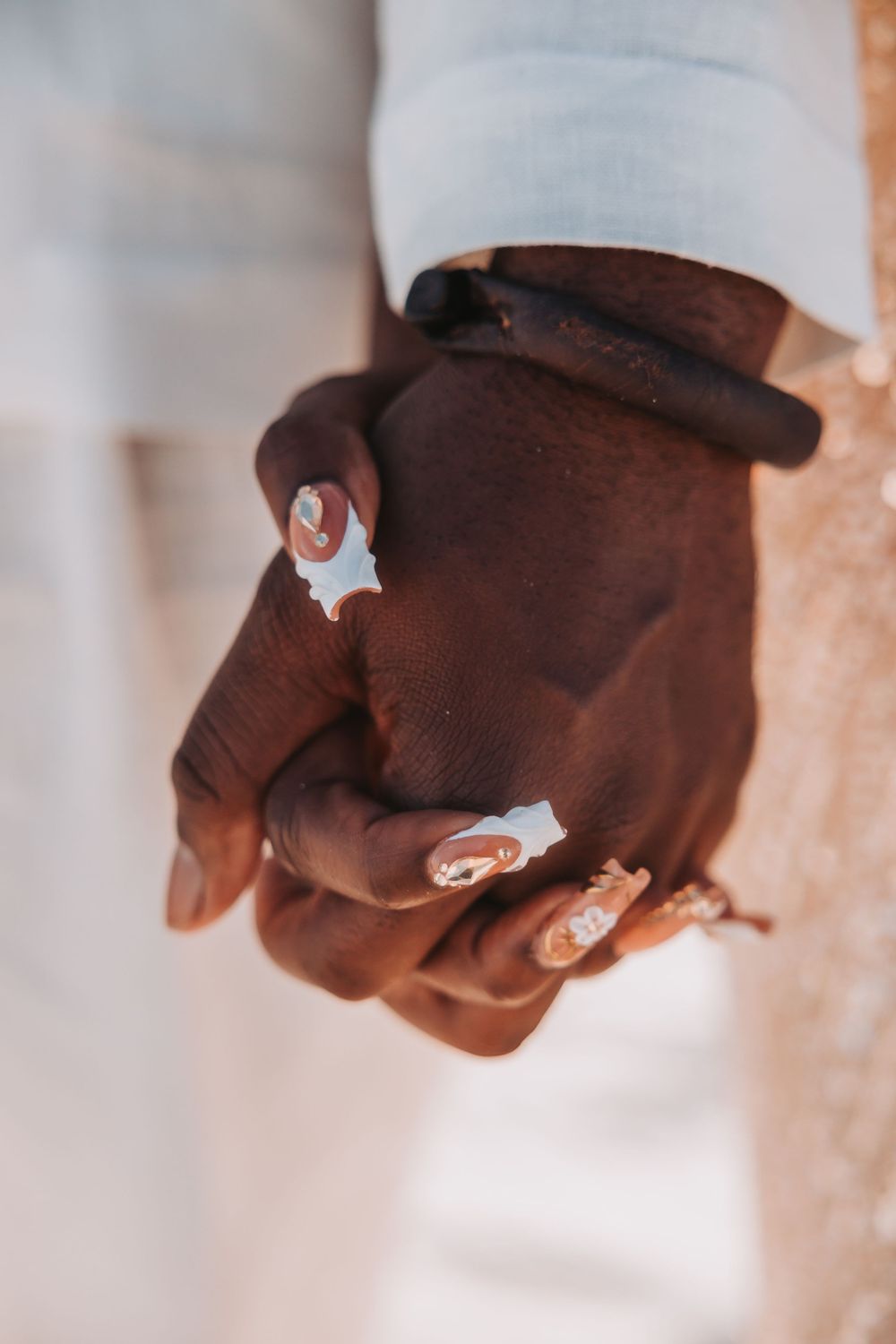 A progression of hands wearing brown gloves using three silver finger control buttons from left to right.