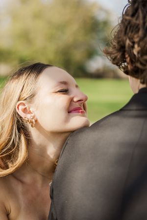 Close-up profile shot of a couple sharing an intimate moment outdoors.