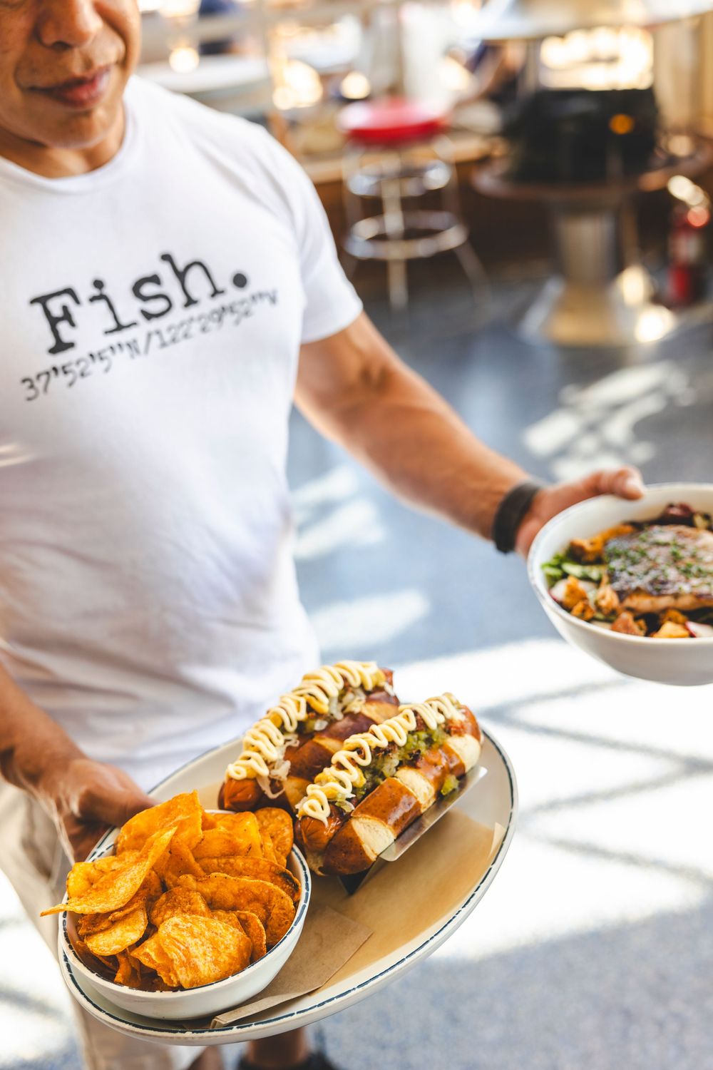 Close-up shots of various seafood dishes and appetizers being served at a restaurant with Fish branding.