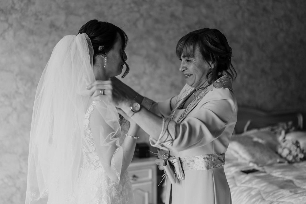 A tender moment between two people during a wedding celebration in black and white photography.