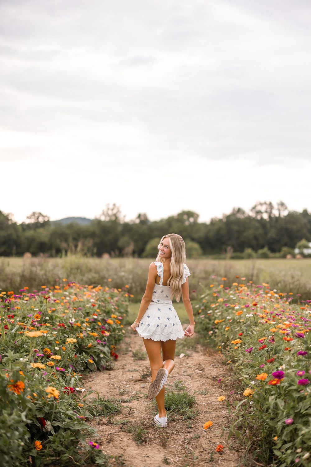 A dreamy scene of a white dress against colorful wildflowers in a field during golden hour.