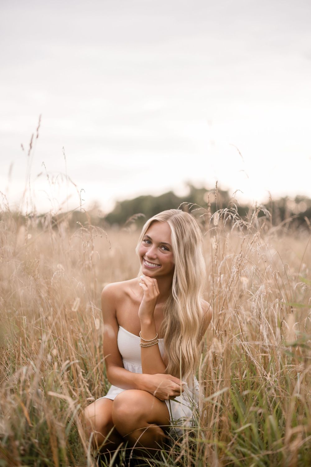 A candid portrait in tall golden grass during sunset with natural lighting.