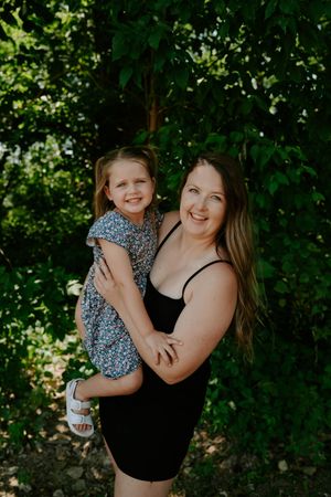 Happy outdoor portrait session with natural greenery in the background.