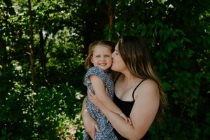 Playful outdoor photography session with leafy green background.