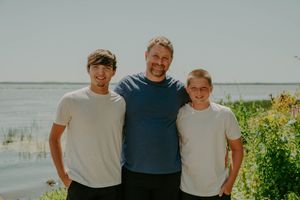 Family group photo captured against a scenic waterfront background.