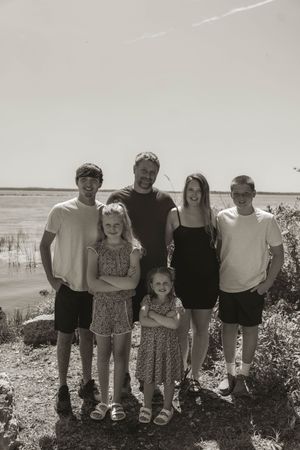 A black and white photo of a group standing together on a coastal landscape.