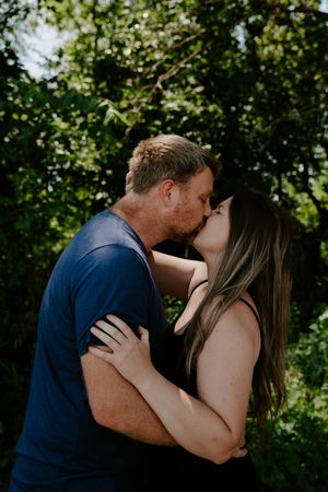 An intimate outdoor portrait session captured in a wooded area with natural lighting.