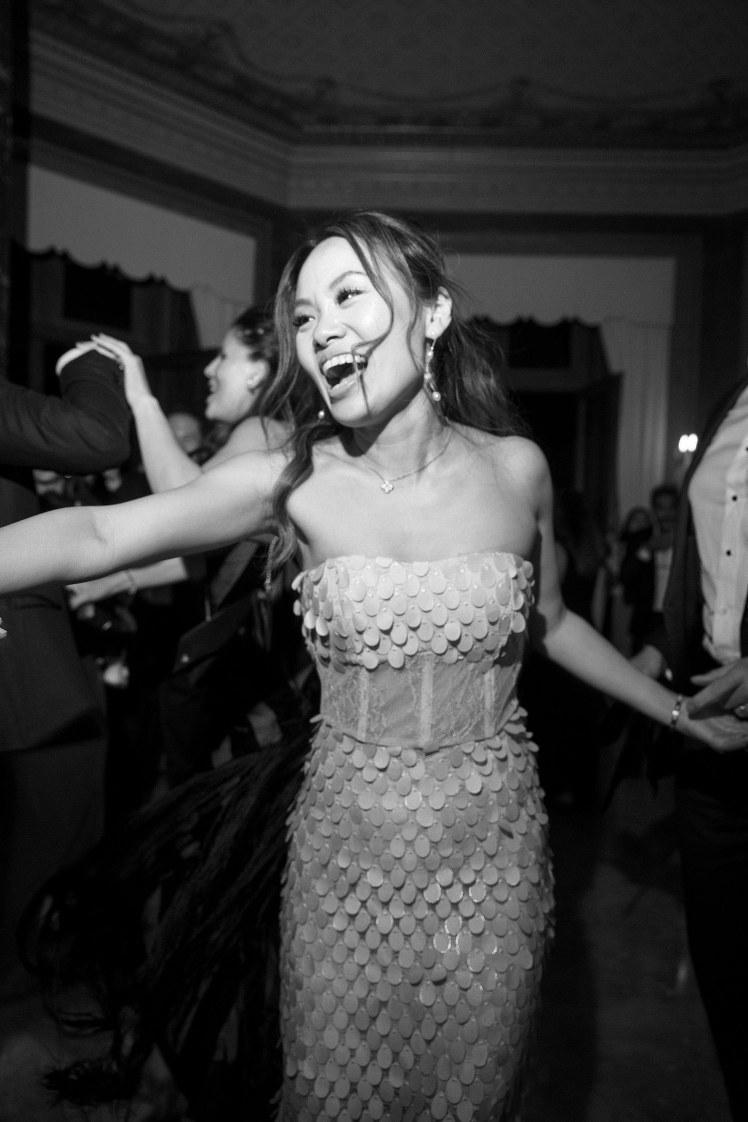 A sequence of black and white photos showing a dancer in a sparkly dress performing energetic movements and expressions.