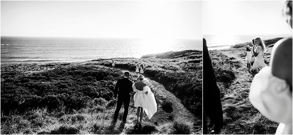 A black and white coastal landscape with figures silhouetted against the ocean view.