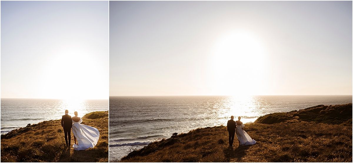 Silhouettes of a couple against a bright ocean sunset on a coastal cliff.
