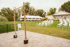 Rows of white wooden chairs set up on a grassy lawn for an outdoor event or wedding ceremony.