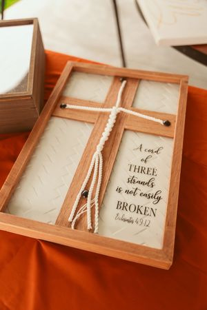 Wooden box display with braided cord and biblical quote 'A cord of three strands is not easily broken' from Ecclesiastes.