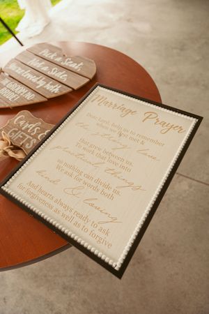 Wedding marriage prayer sign displayed on wooden surface with elegant script text.