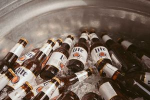 Glass bottles chilling in ice at an outdoor event setup.