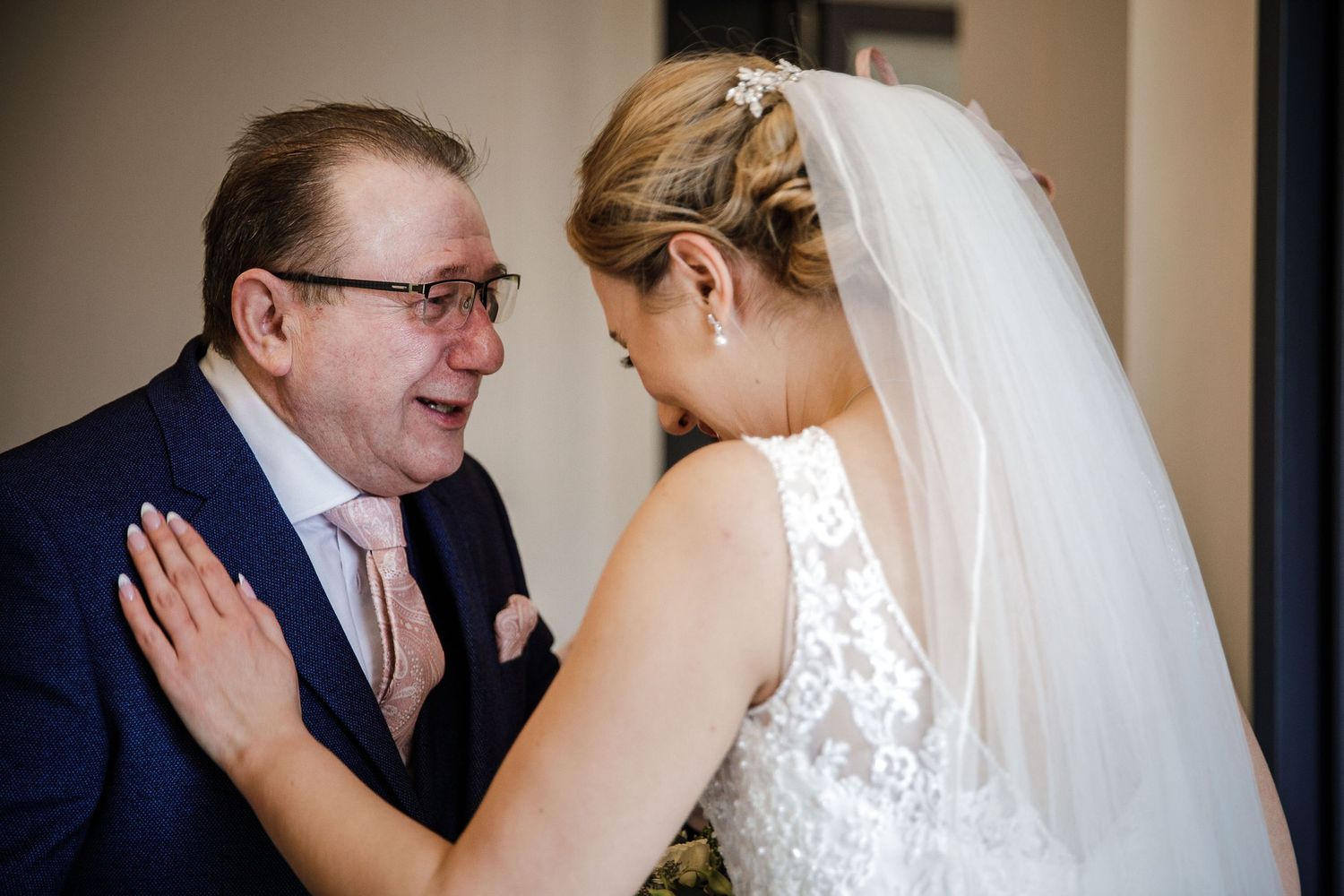 Wedding couple sharing intimate moments in formal attire indoors.