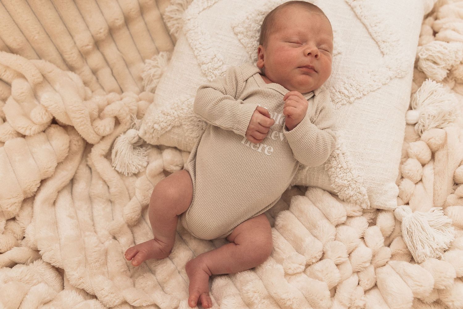 Soft and cozy nursery scene with a teddy bear stuffed animal and corduroy bedding in neutral beige tones.