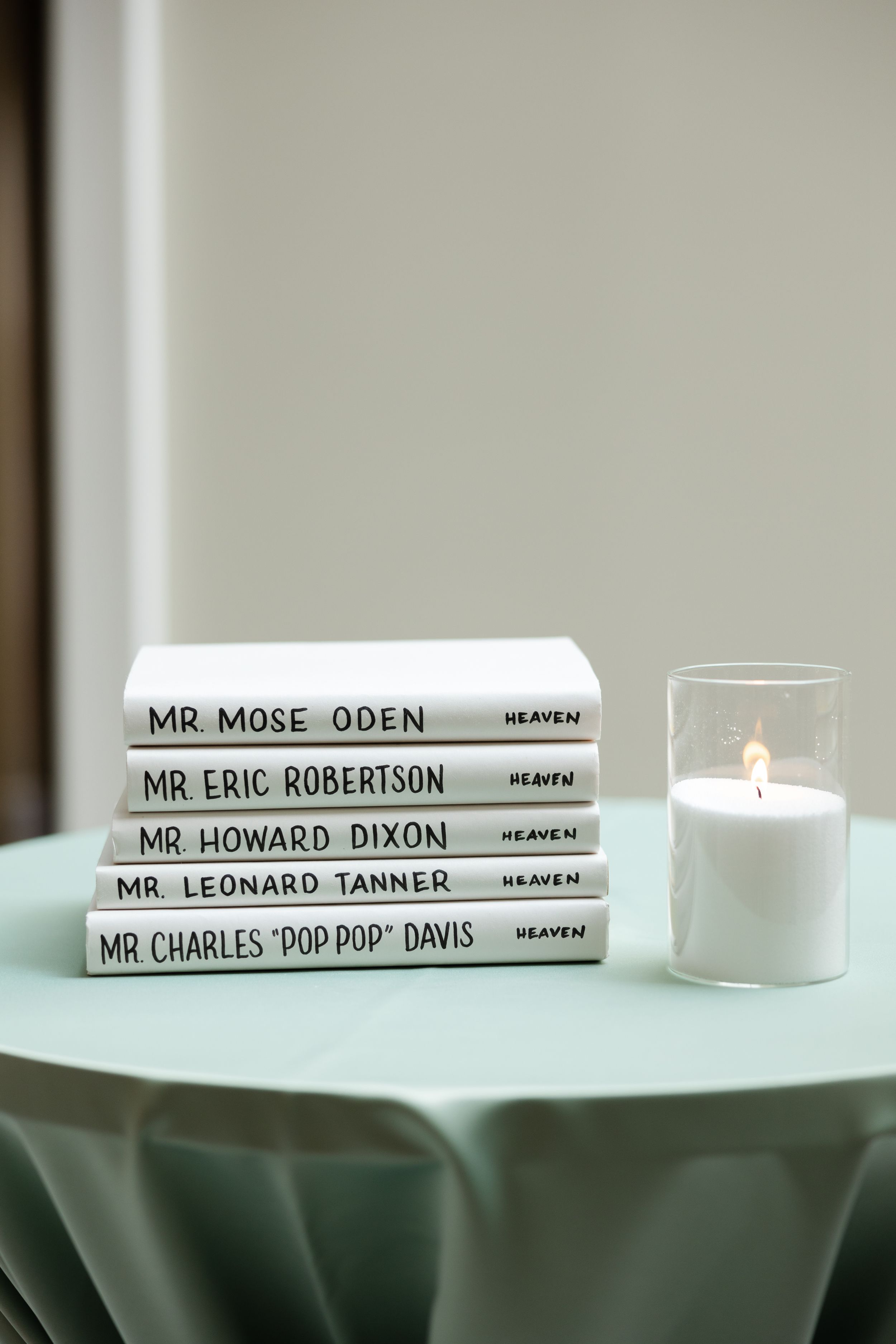 Several books stacked on a white surface with titles including Mr. Mose Oden and other names visible on their spines.