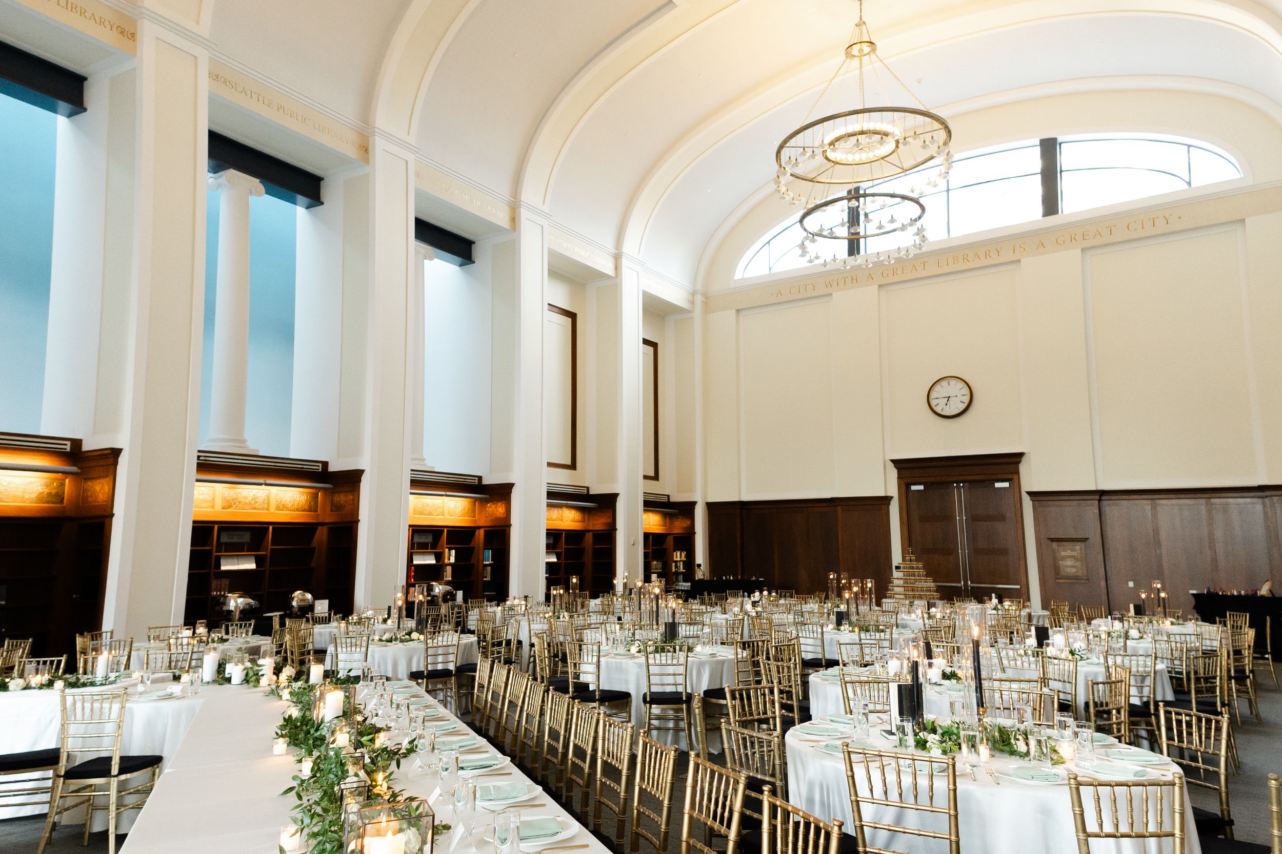 Elegant banquet hall with white tablecloths, arched windows, and ornate ceiling details set for a formal event.