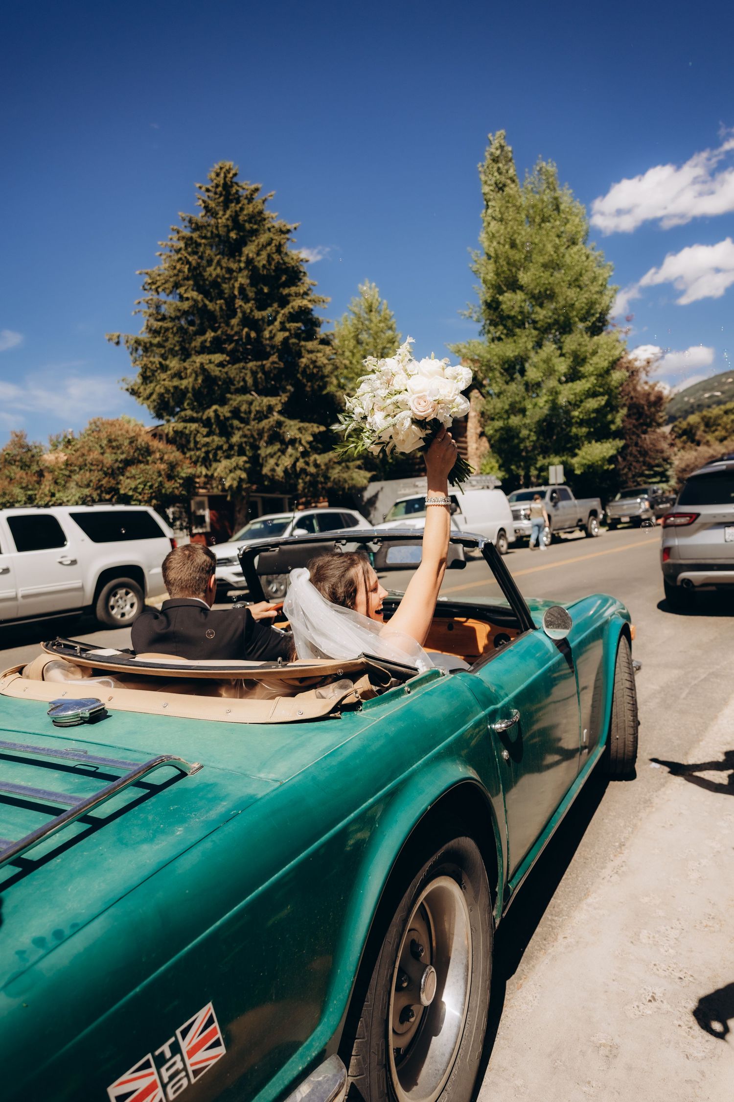 A series of photos showing people relaxing in a vintage turquoise convertible car parked in a sunny parking lot.