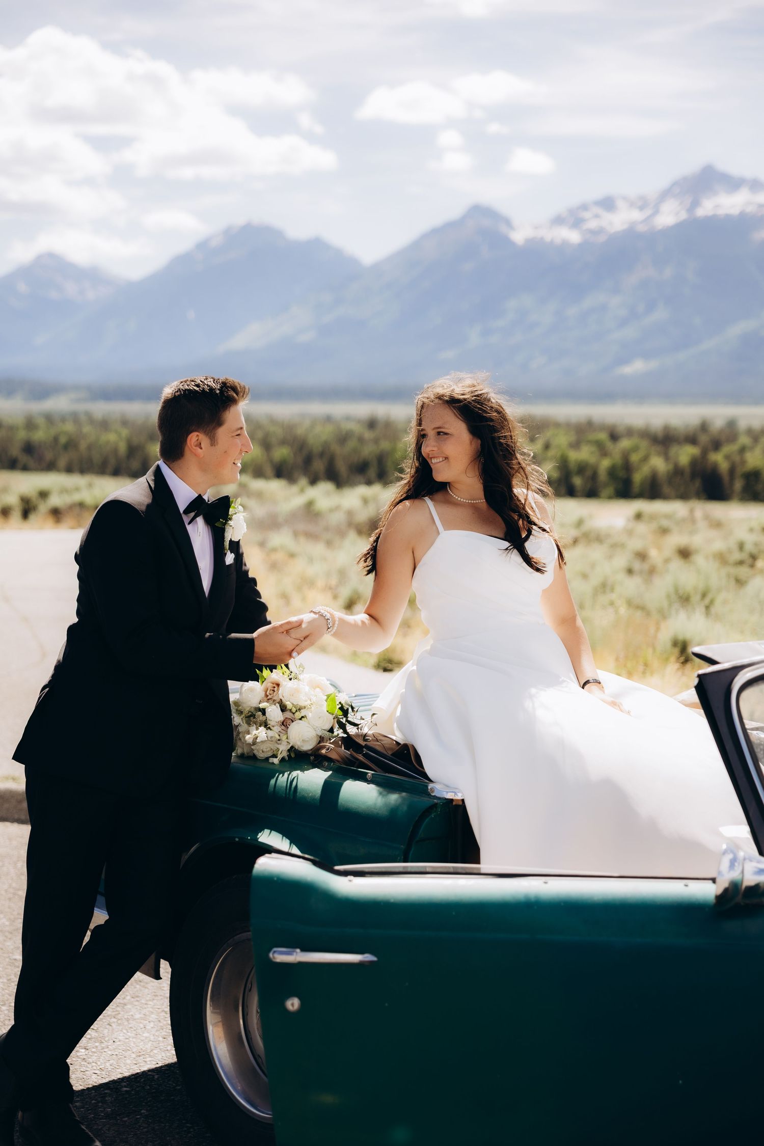 A couple shares intimate moments by a vintage car with scenic mountain views in the background across four sequential photos.